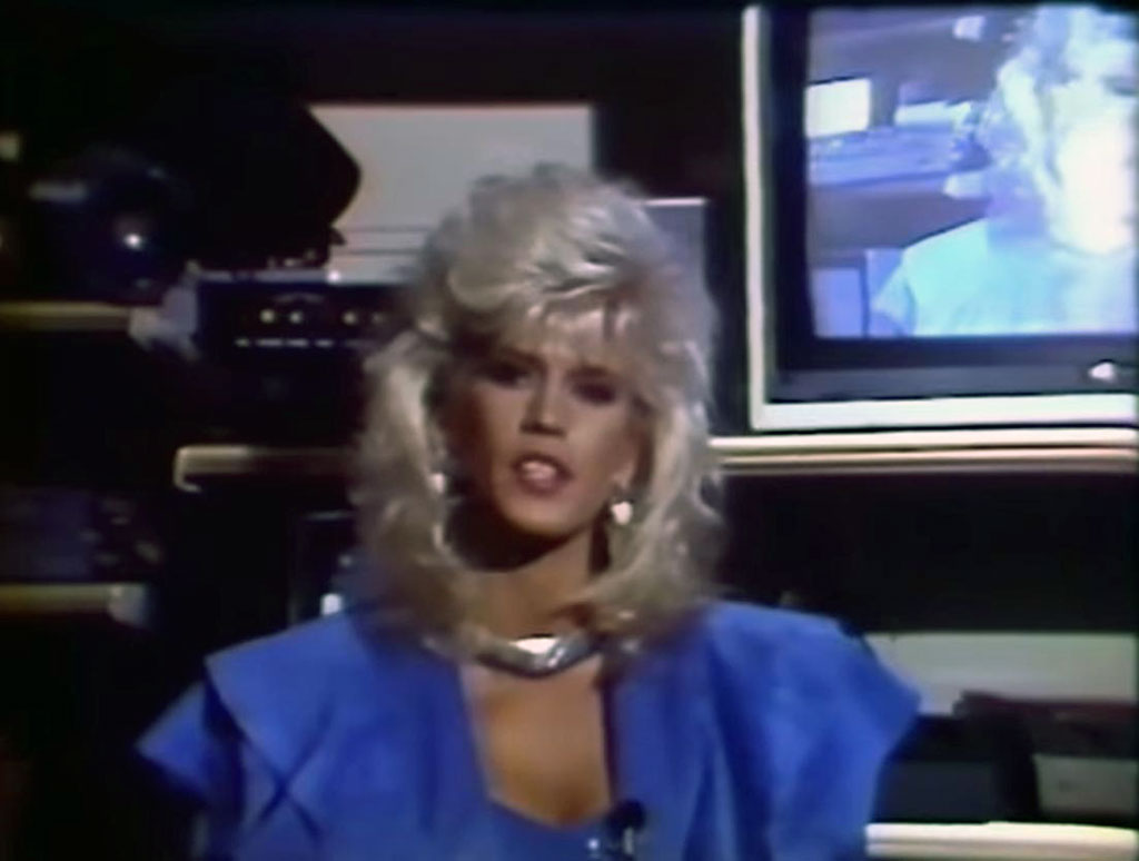 Porn star Amber Lynn sits in front of a TV monitor